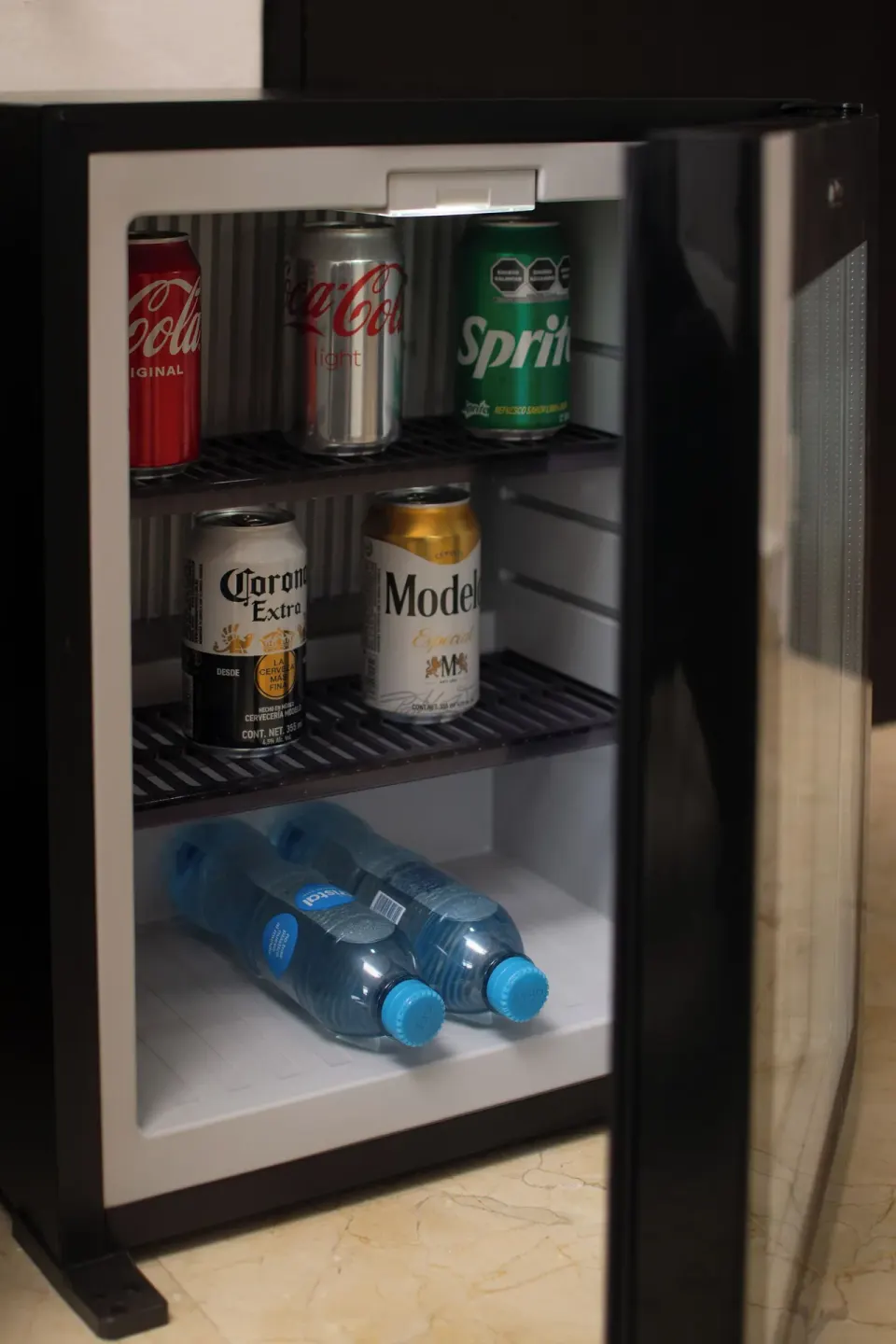 Close-up of stocked mini fridge with canned drinks at Flamingo Cancun.