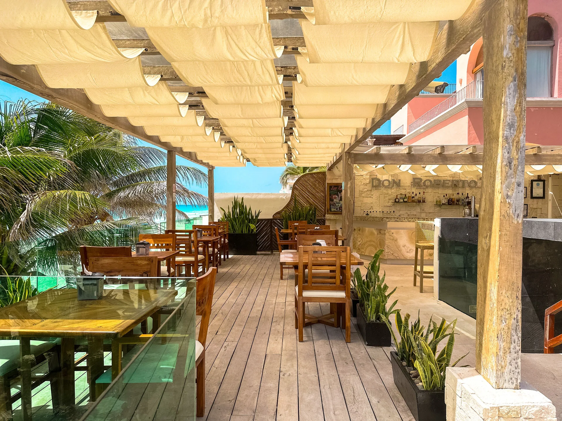 Outdoor terrace seating beside Don Robertos Bar & Pizza at Flamingo Cancun.
