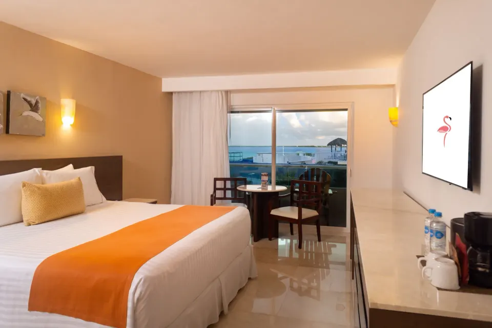 Deluxe Room Lagoon View with king bed and balcony seating at Flamingo Cancun.