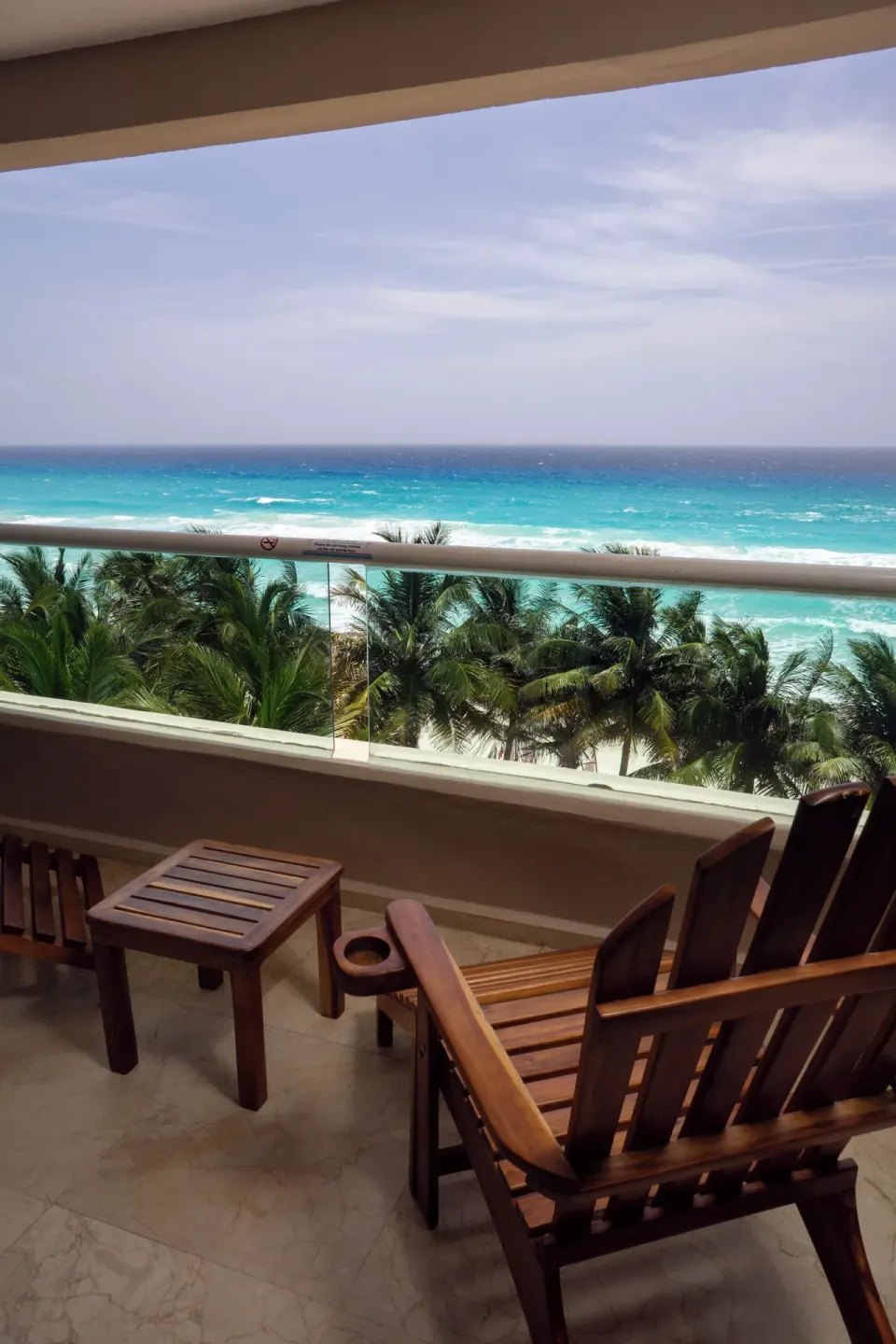 Deluxe Room Ocean View balcony with chairs overlooking the sea at Flamingo Cancun.