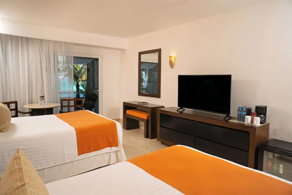 Deluxe Room Ocean View with two beds and TV at Flamingo Cancun.