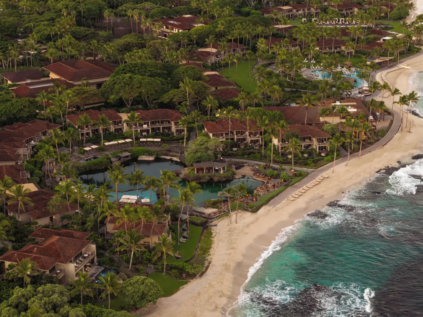 Aerial view of resort buildings, lagoons and beach at Four Seasons Resort Hualalai.