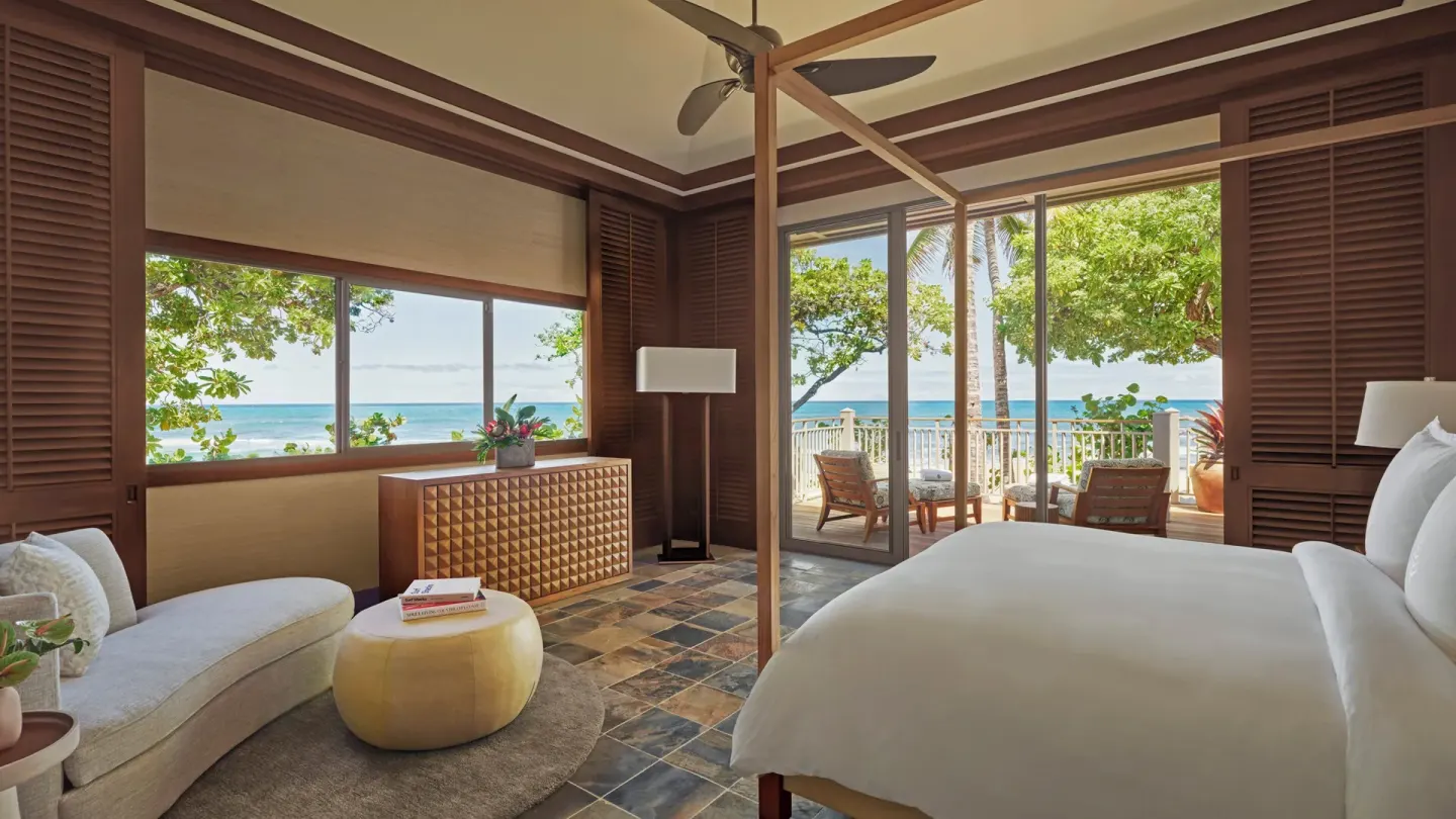 Ocean-view bedroom with four-poster king bed and corner seating at Four Seasons Resort Hualalai.