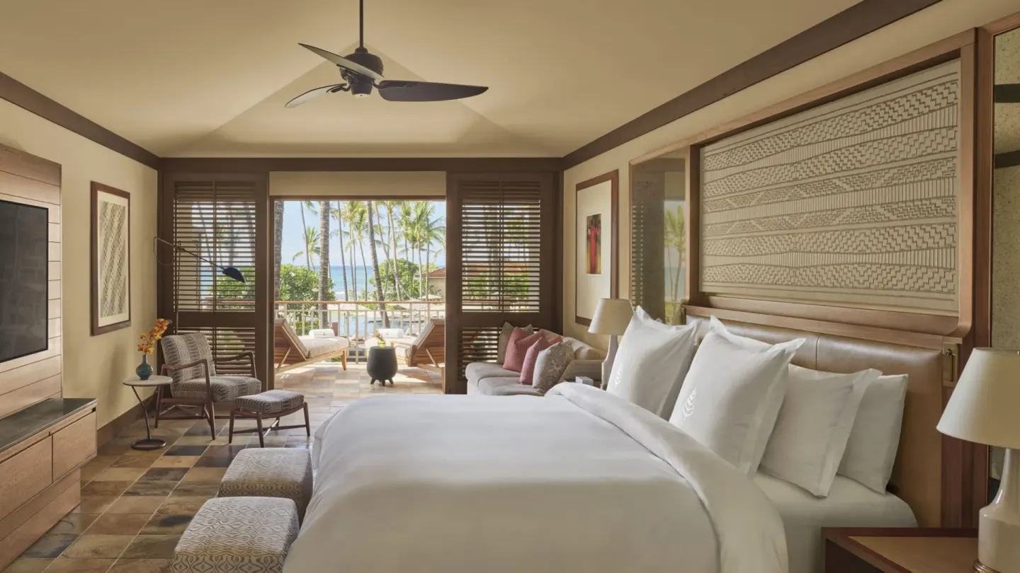 King bedroom with balcony and partial ocean view at Four Seasons Resort Hualalai.