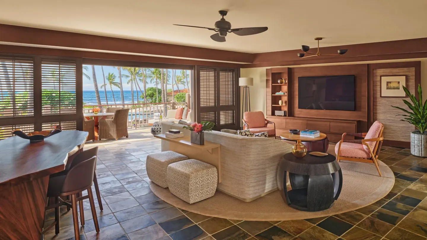 Ocean-view suite living room with sofa, dining counter, and balcony at Four Seasons Resort Hualalai.