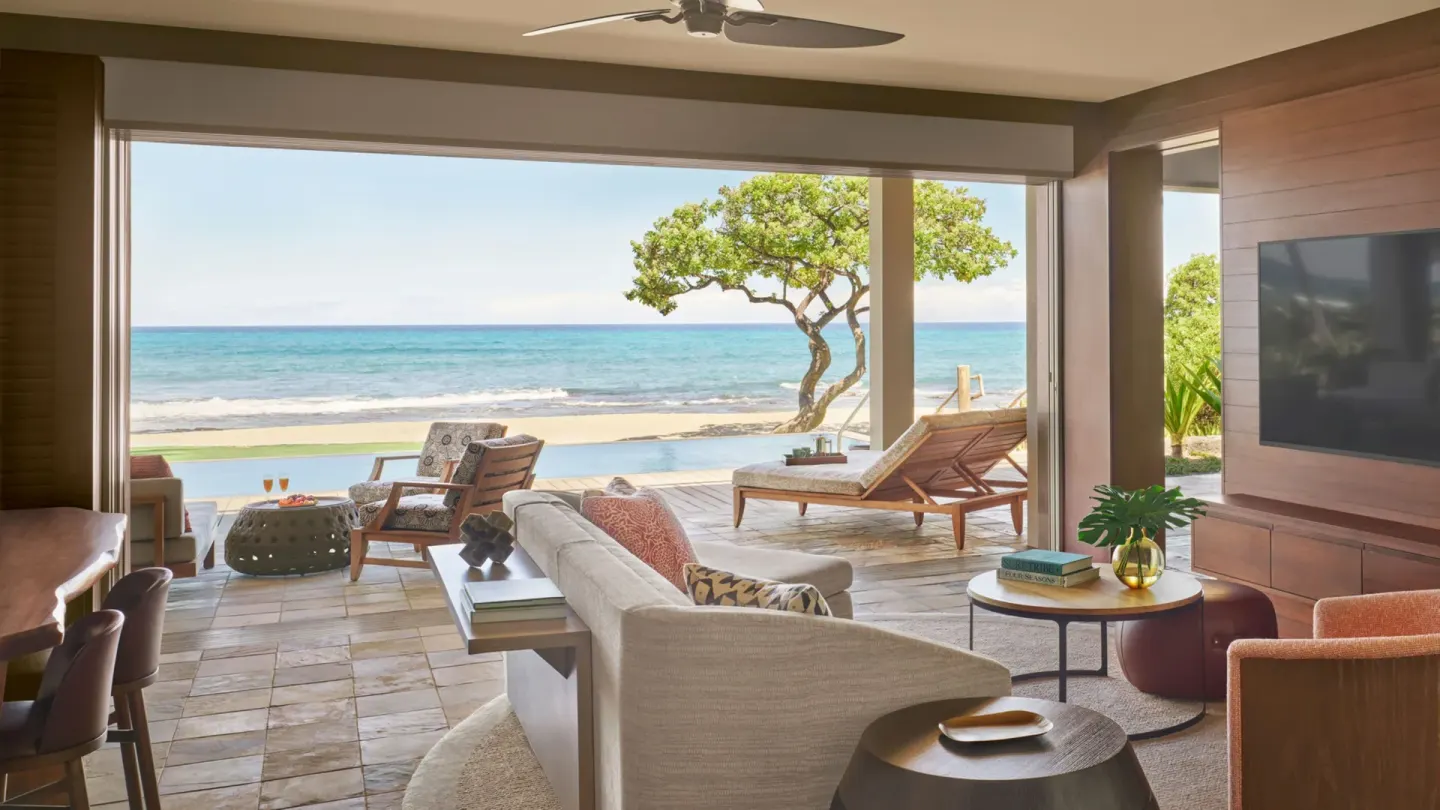 Oceanfront suite living area with lanai loungers at Four Seasons Resort Hualalai.