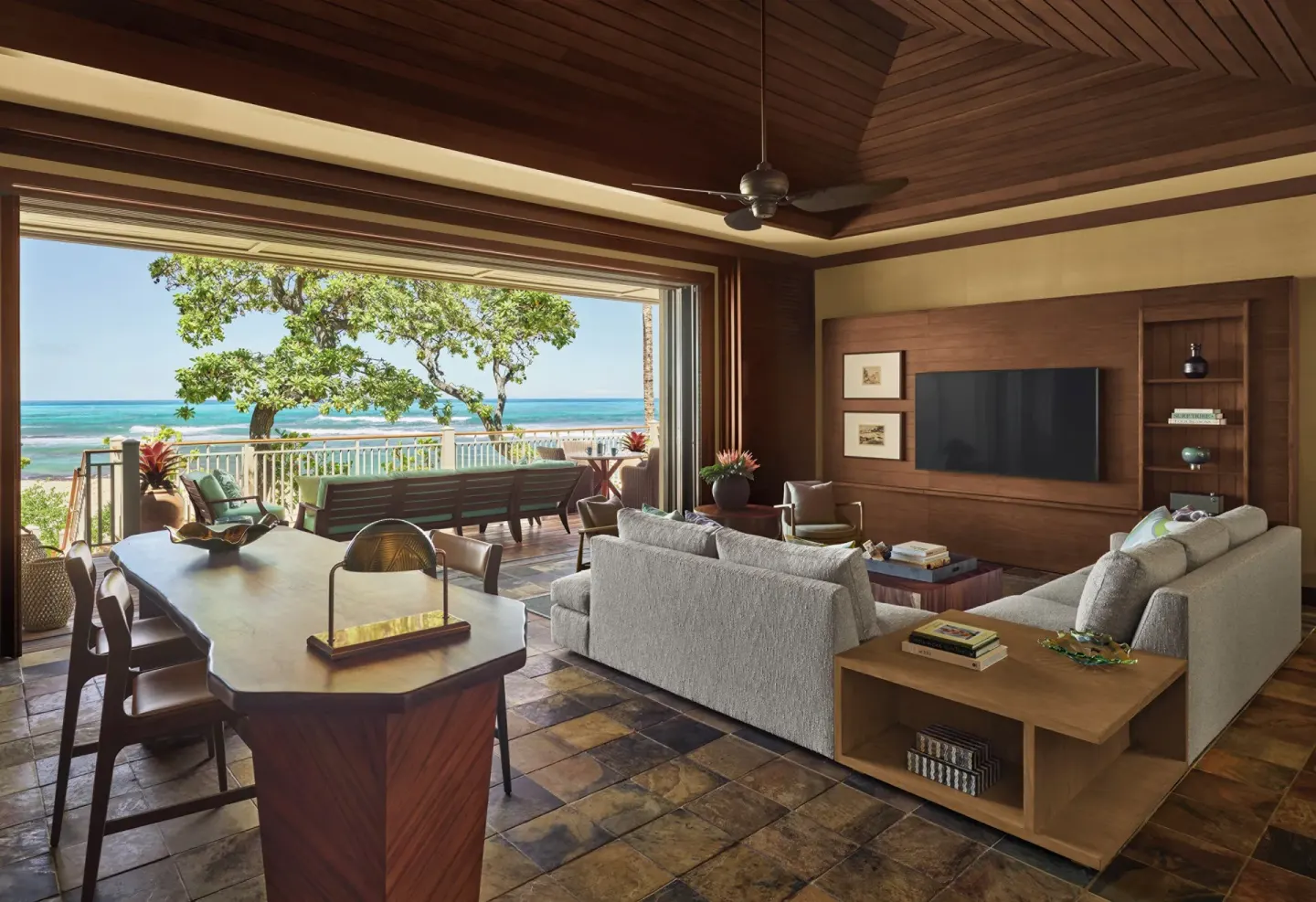 Oceanfront suite living room with vaulted wood ceiling and open lanai at Four Seasons Resort Hualalai.
