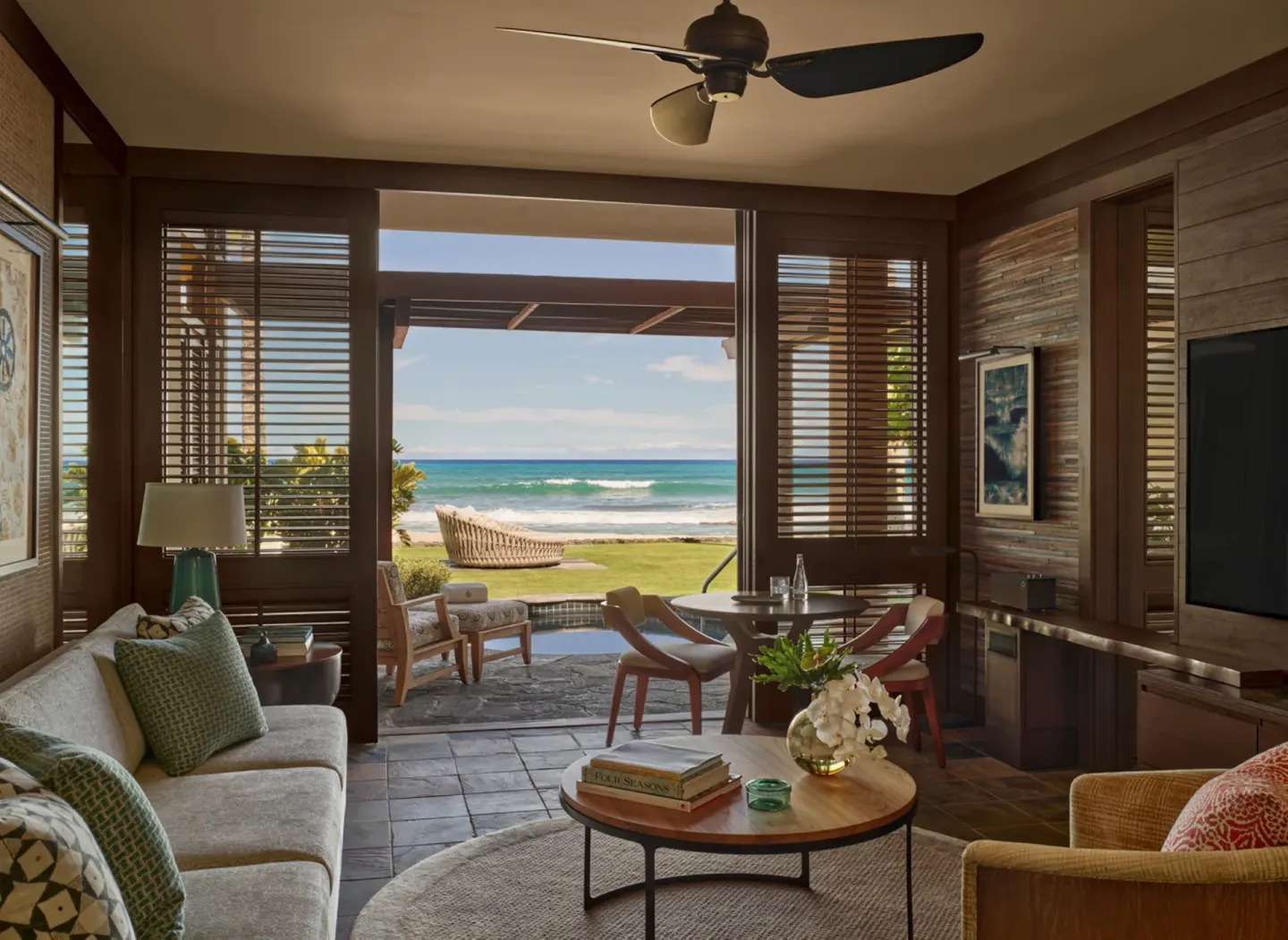 Oceanfront living room with dining table at Four Seasons Resort Hualalai.