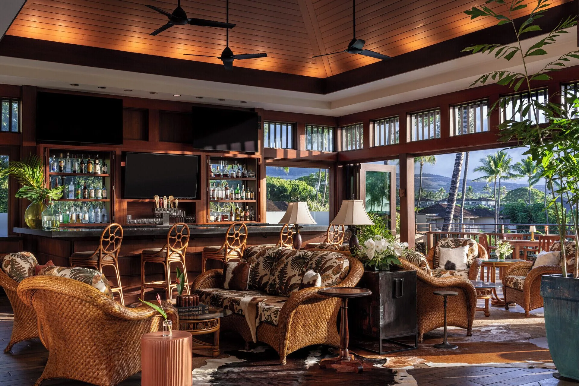 Bar lounge with wicker seating and open windows at Four Seasons Resort Hualalai.
