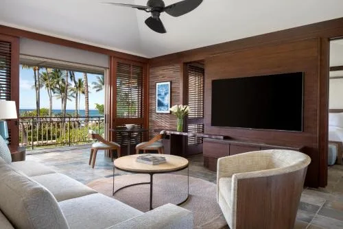 Superior Suite Prime Ocean View sitting area at Four Seasons Resort Hualalai with TV and balcony doors.
