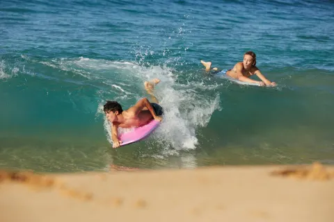 Boogie boarders ride a shore break near Four Seasons Resort Maui at Wailea.