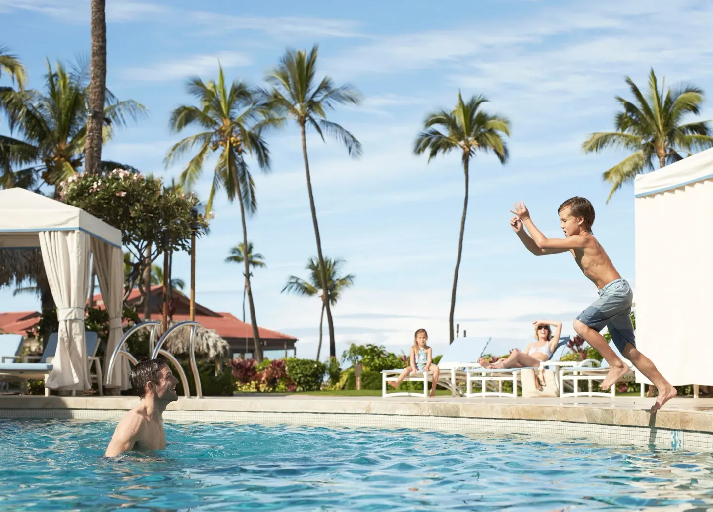 Child jumping into a resort pool at Four Seasons Resort Maui at Wailea.