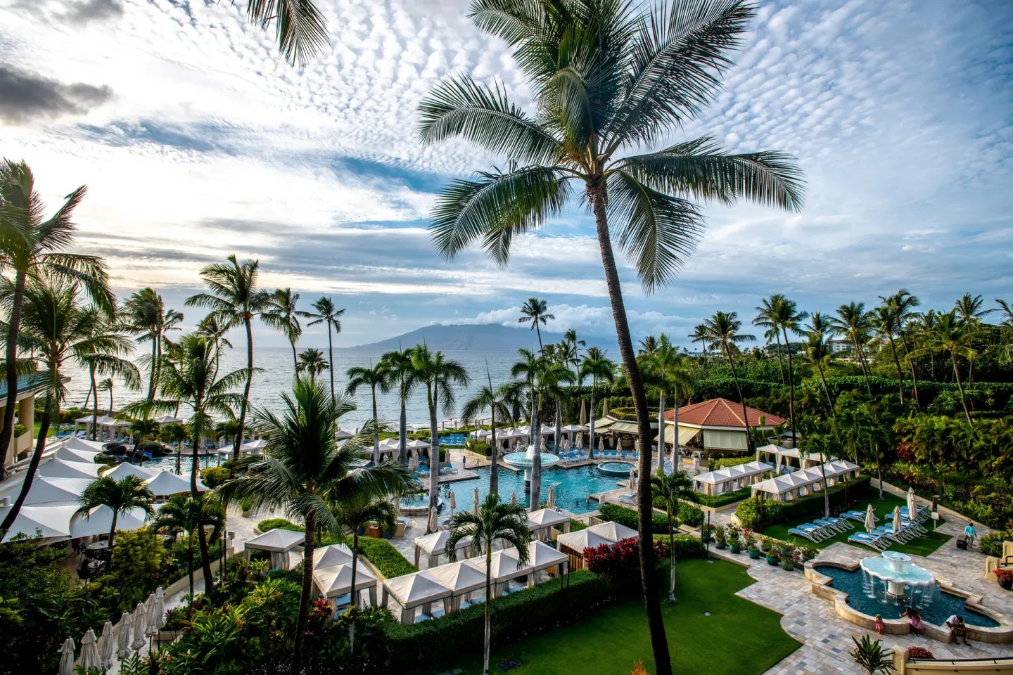Elevated view of pools, cabanas, palms, and ocean at Four Seasons Resort Maui at Wailea.