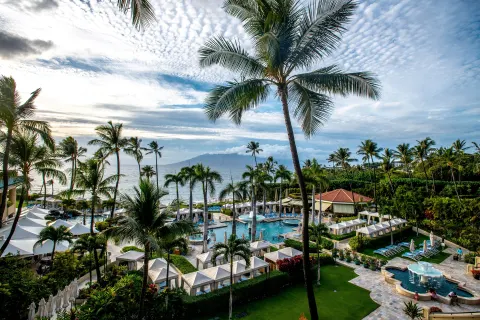 Elevated view of pools, cabanas, palms, and ocean at Four Seasons Resort Maui at Wailea.