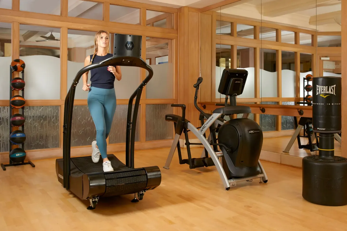 Woman using a curved treadmill in the fitness center at Four Seasons Resort Maui at Wailea.