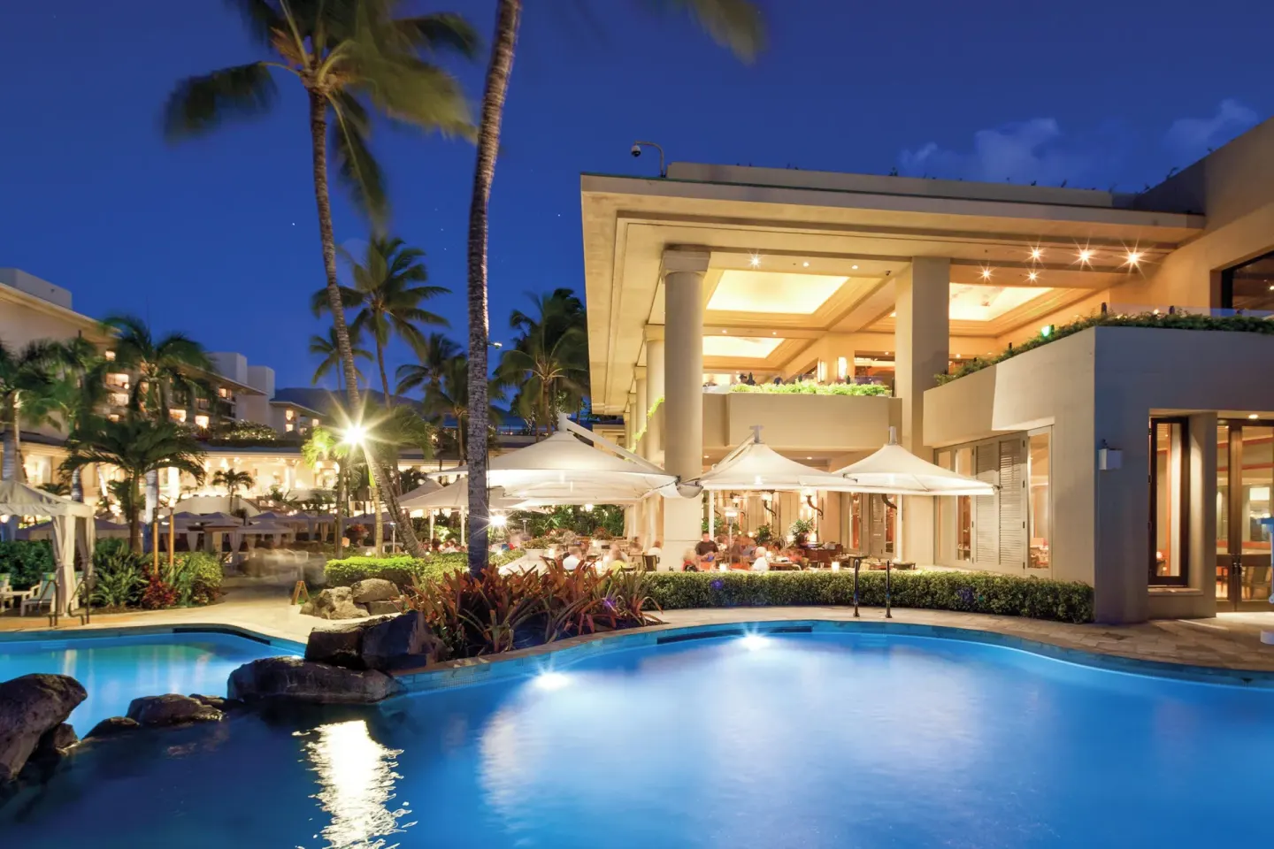 Night view of illuminated pool and terrace at Four Seasons Resort Maui at Wailea.