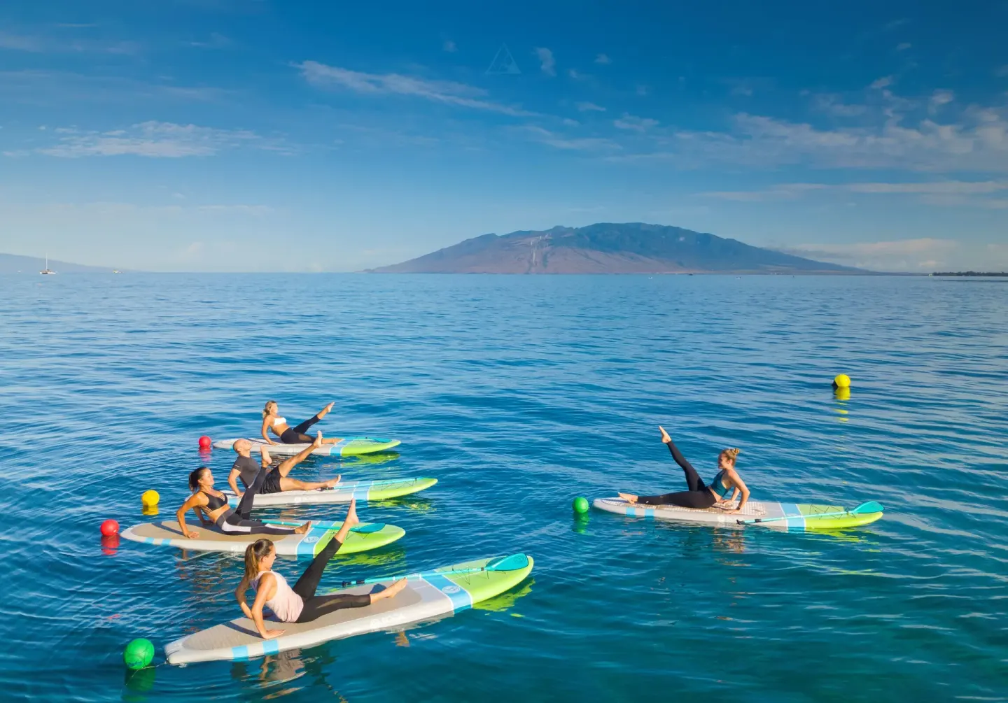 Guests doing paddleboard fitness on the ocean at Four Seasons Resort Maui at Wailea.