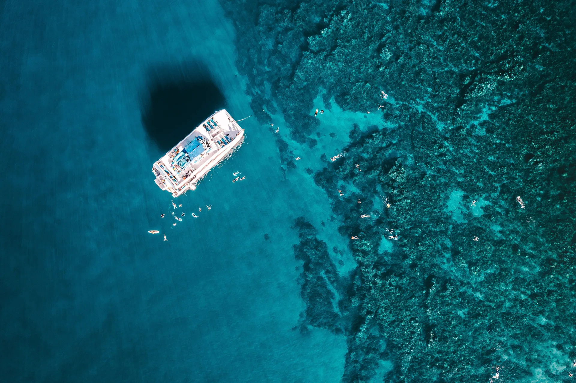 Aerial view of swimmers around a boat over a reef near Four Seasons Resort Maui at Wailea.