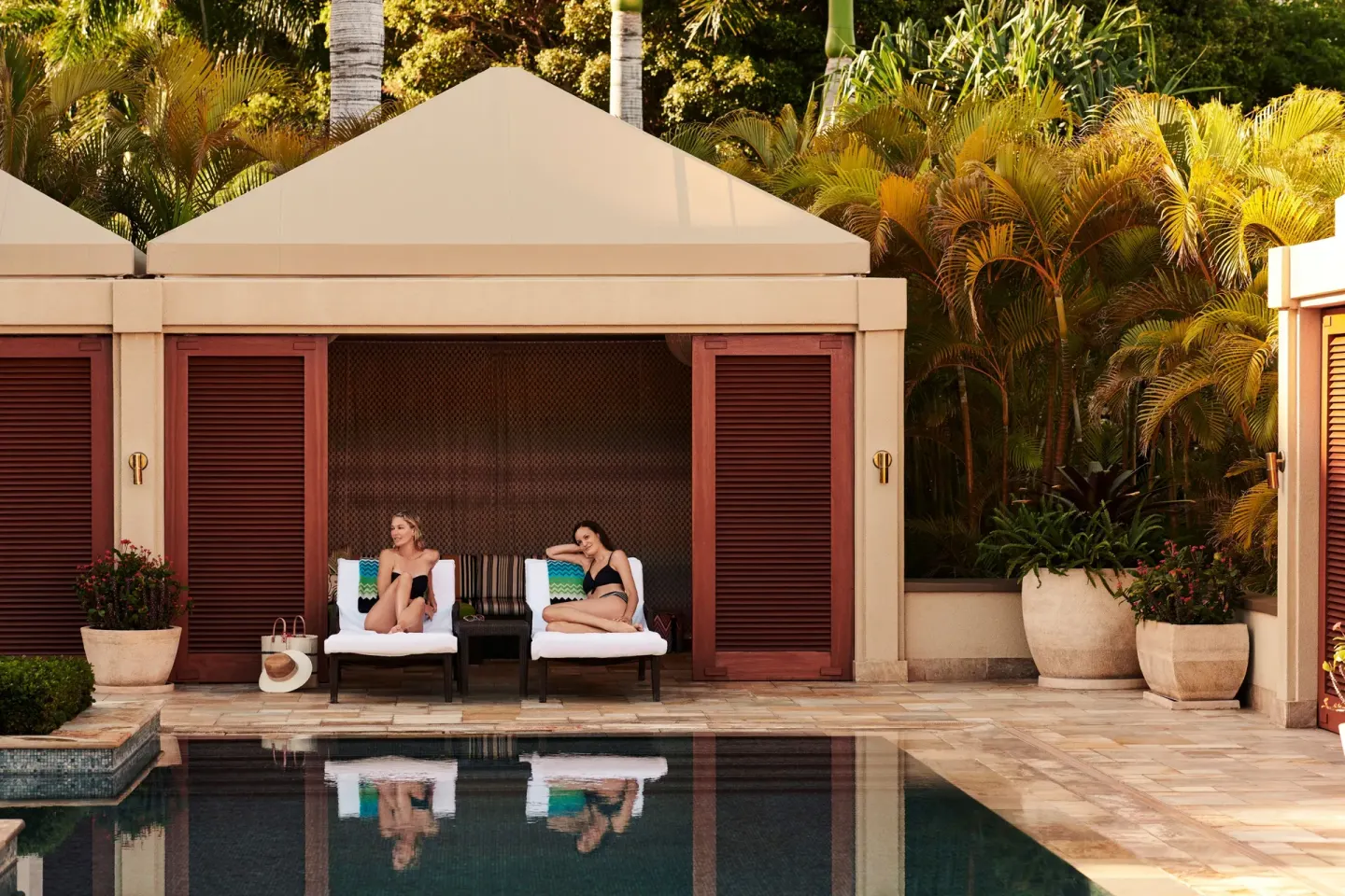 Shaded pool cabana with two lounge chairs at Four Seasons Resort Maui at Wailea.
