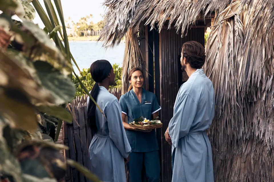 Guests in robes speaking with a spa attendant at Four Seasons Resort Maui at Wailea.