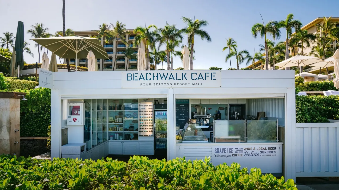 Beachwalk Café kiosk stands by greenery at Four Seasons Resort Maui at Wailea.