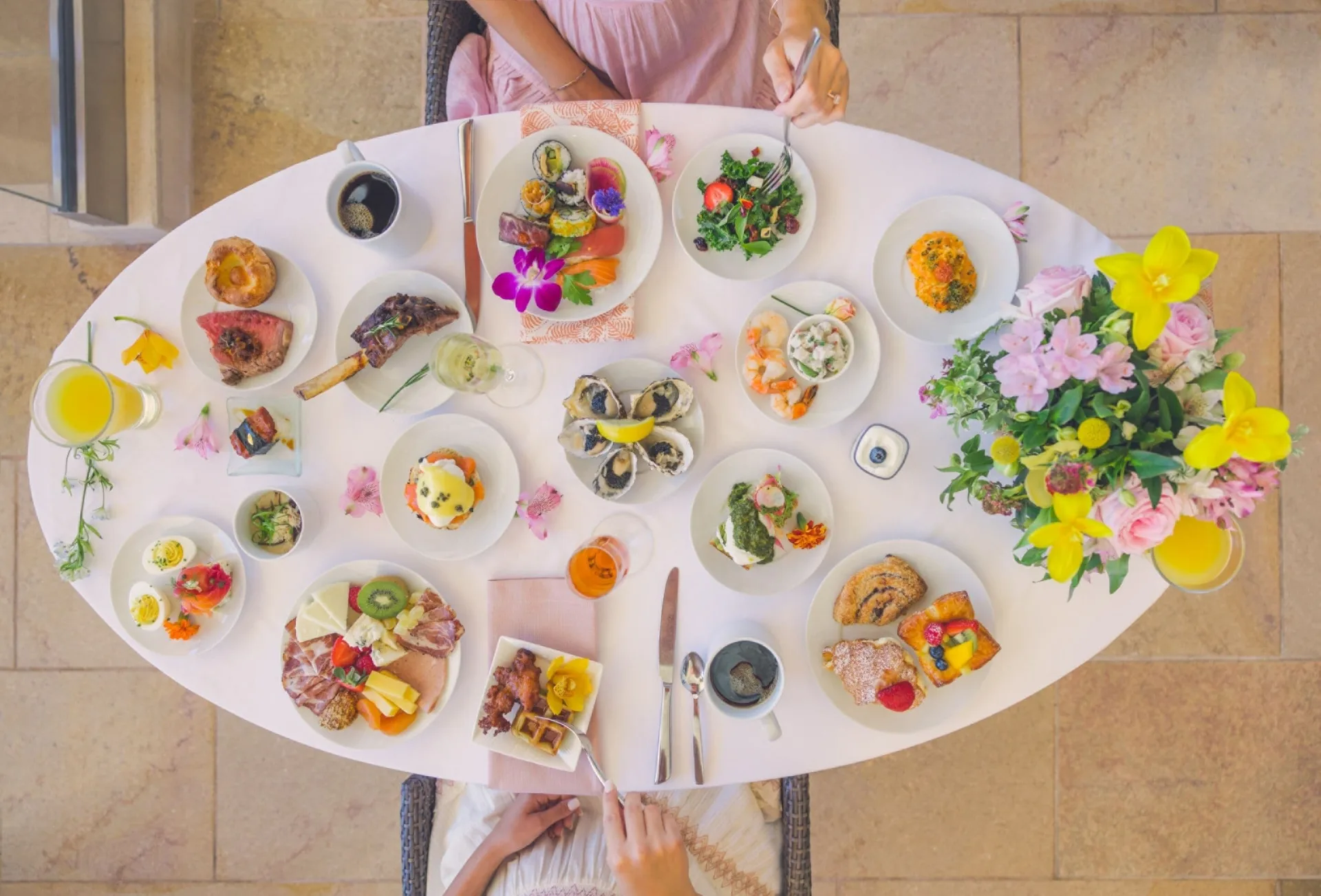 Overhead brunch table with seafood, pastries, fruit, and flowers at Four Seasons Resort Maui at Wailea.
