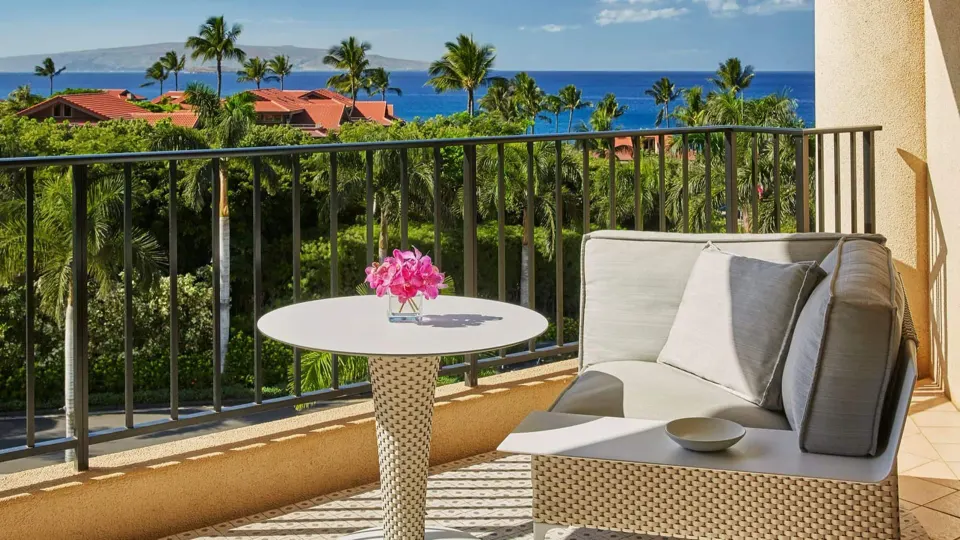 Deluxe Ocean View Room balcony seating and Pacific view at Four Seasons Resort Maui at Wailea.