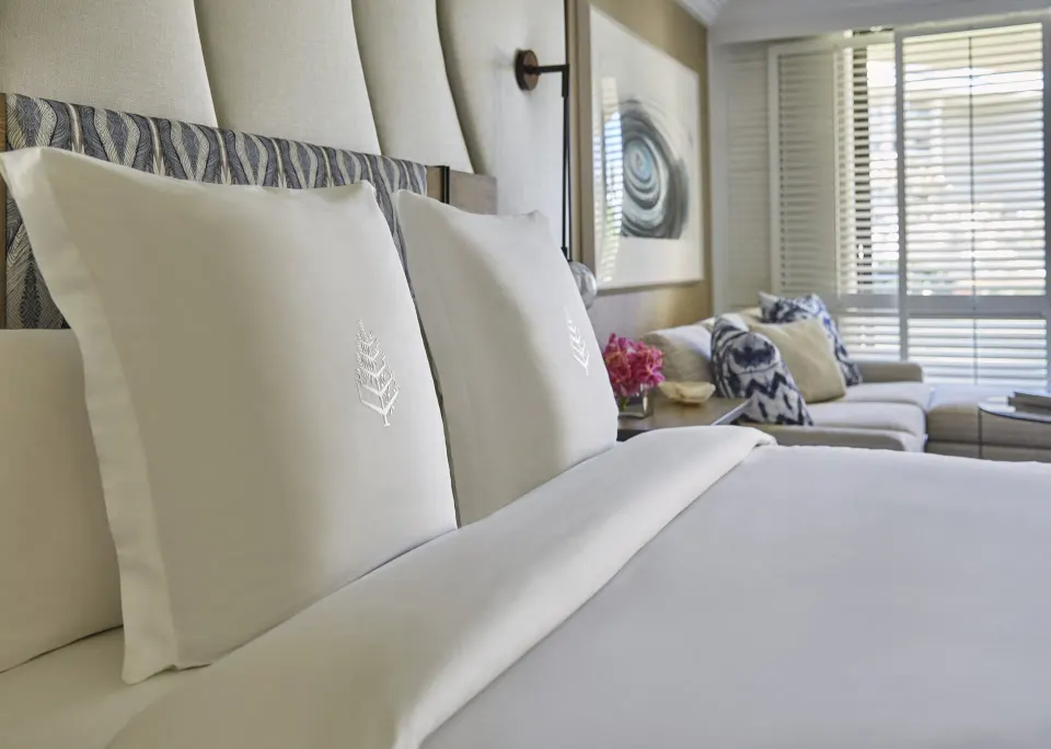 Garden View Accessible Room king bed at Four Seasons Resort Maui at Wailea with sofa and shuttered windows.