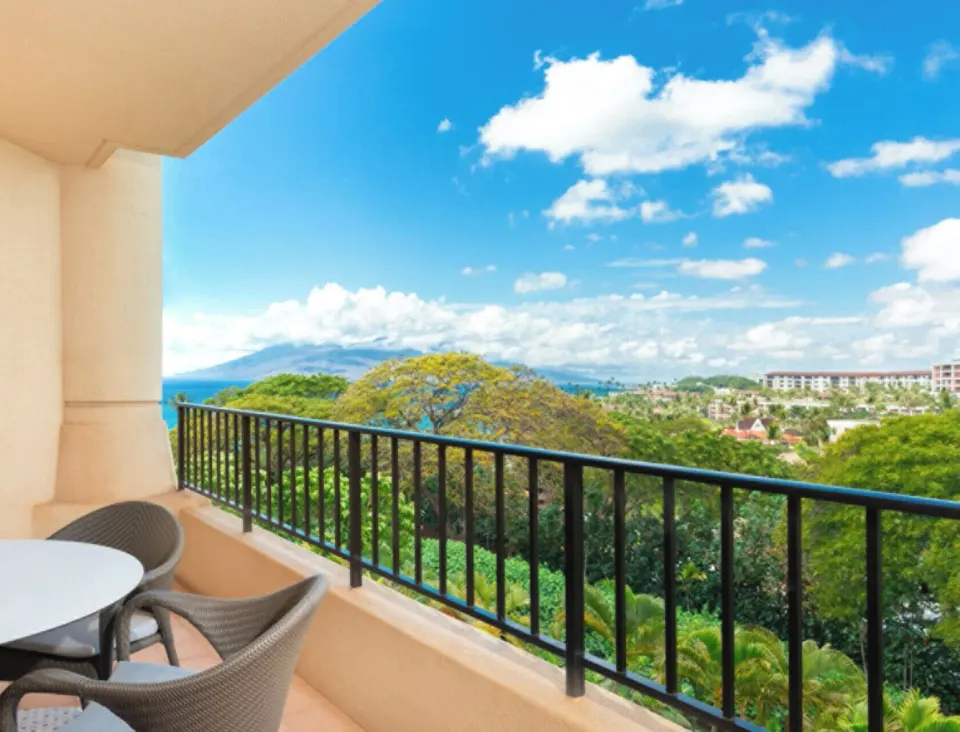 Garden View Room balcony at Four Seasons Resort Maui at Wailea overlooking trees, ocean, and sky.