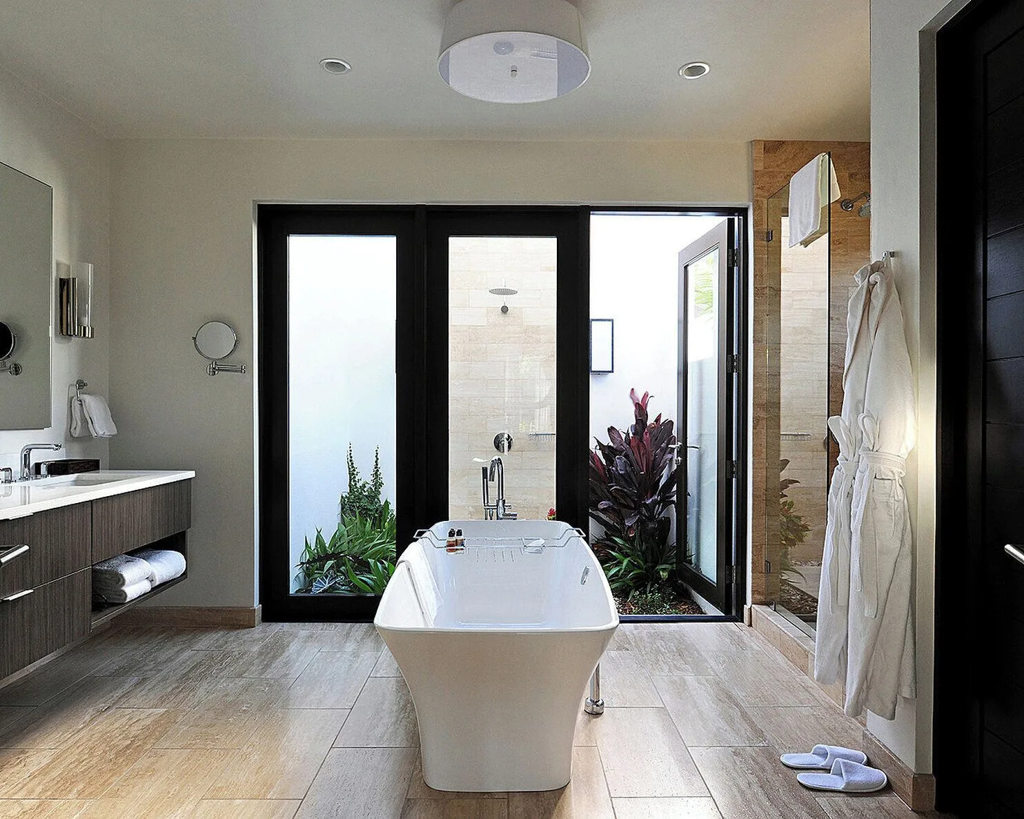 Freestanding tub and glass shower in a bathroom at Four Seasons Resort Nevis.