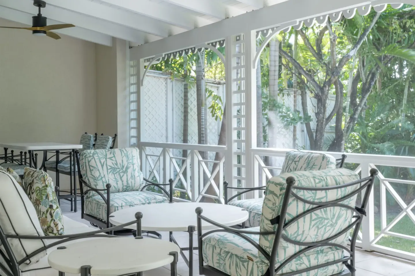 Covered veranda seating with leafy garden views at Four Seasons Resort Nevis.