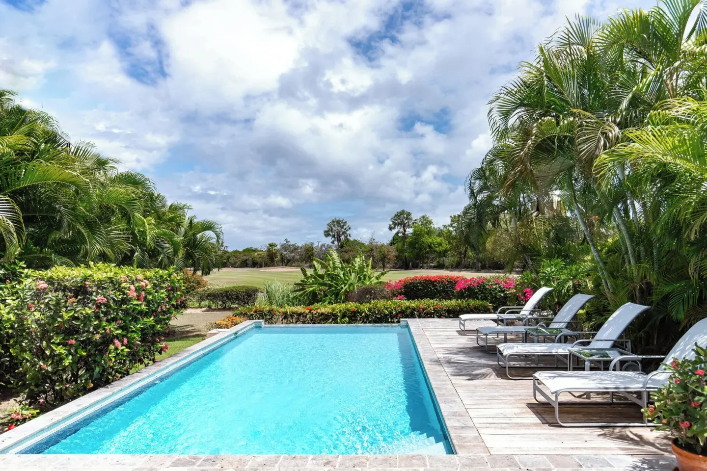 Garden pool with lounge chairs and palms at Four Seasons Resort Nevis.