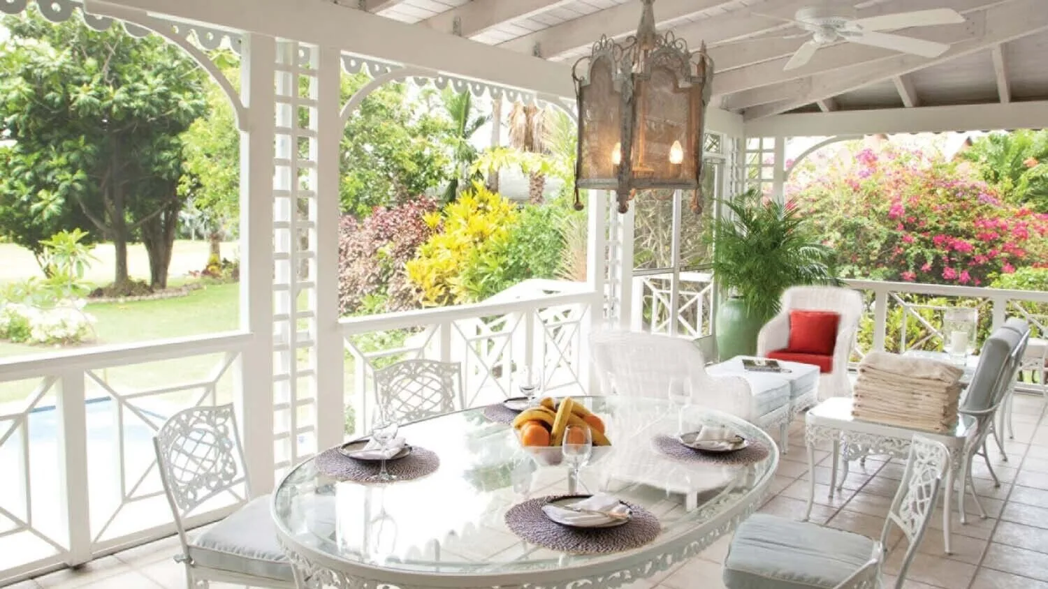 Garden veranda dining table with lounge chairs at Four Seasons Resort Nevis.