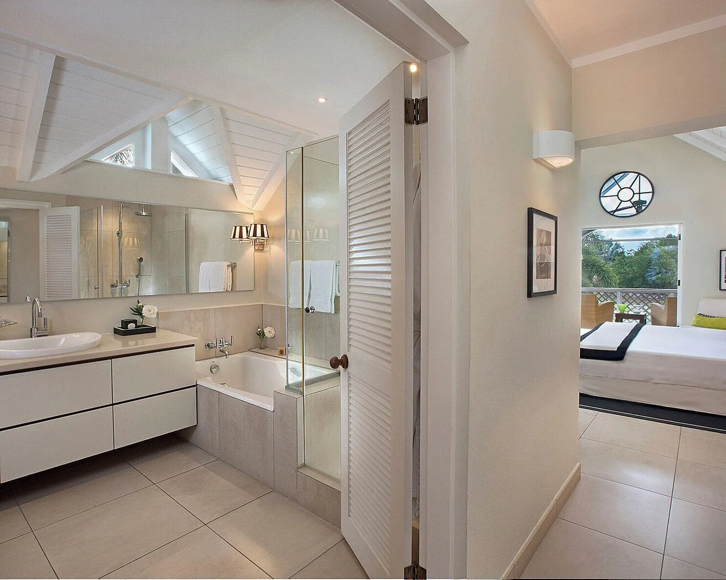 Guest room bathroom and bed area at Four Seasons Resort Nevis.