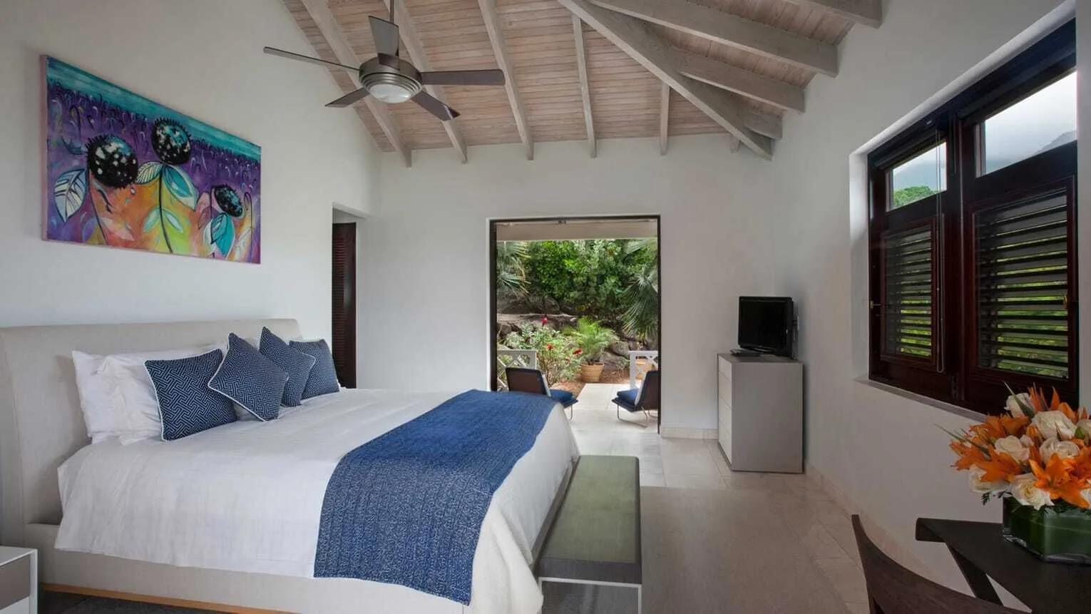 King bedroom with vaulted ceiling and garden doorway at Four Seasons Resort Nevis.