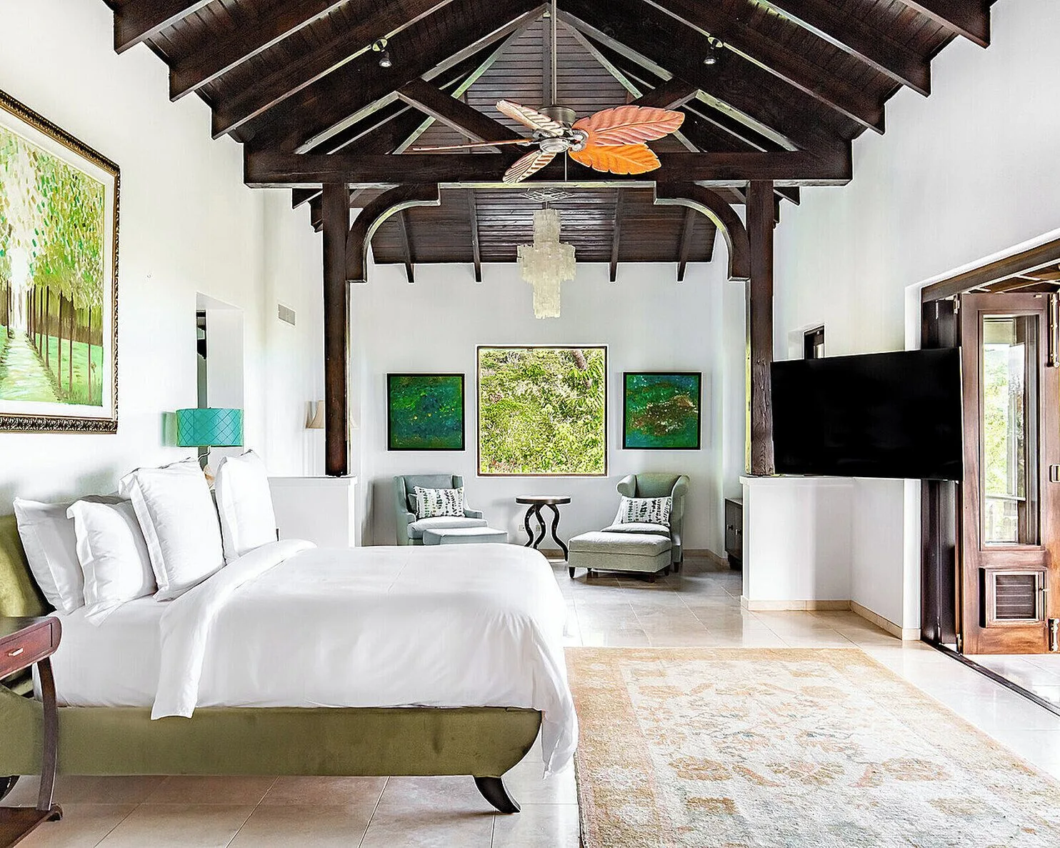 Guest room with king bed, sitting area and dark wood ceiling at Four Seasons Resort Nevis.