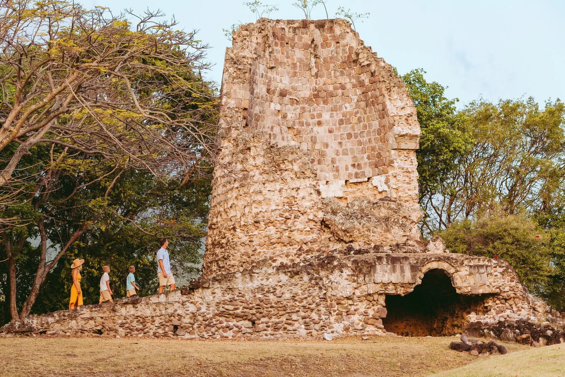 Stone ruin with guests walking beside it at Four Seasons Resort Nevis.