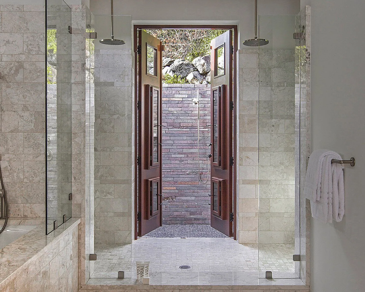 Walk-in shower and open doors to an outdoor shower at Four Seasons Resort Nevis.
