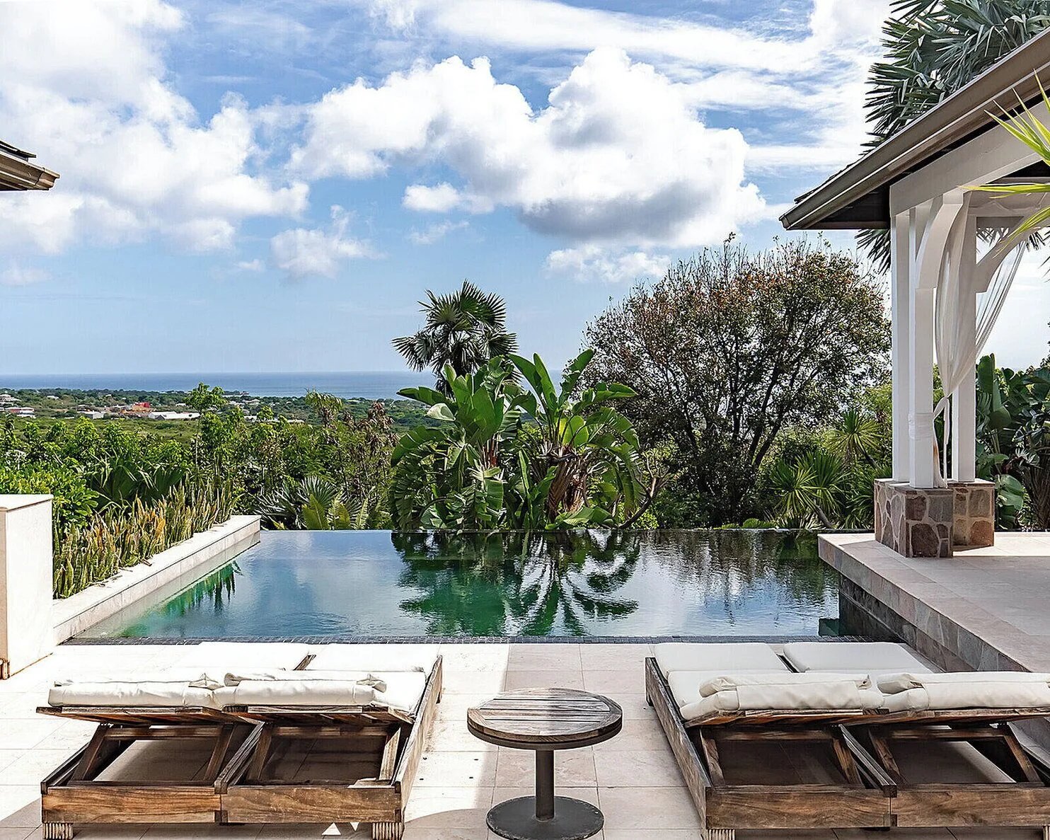 Infinity pool with loungers and ocean view at Four Seasons Resort Nevis.