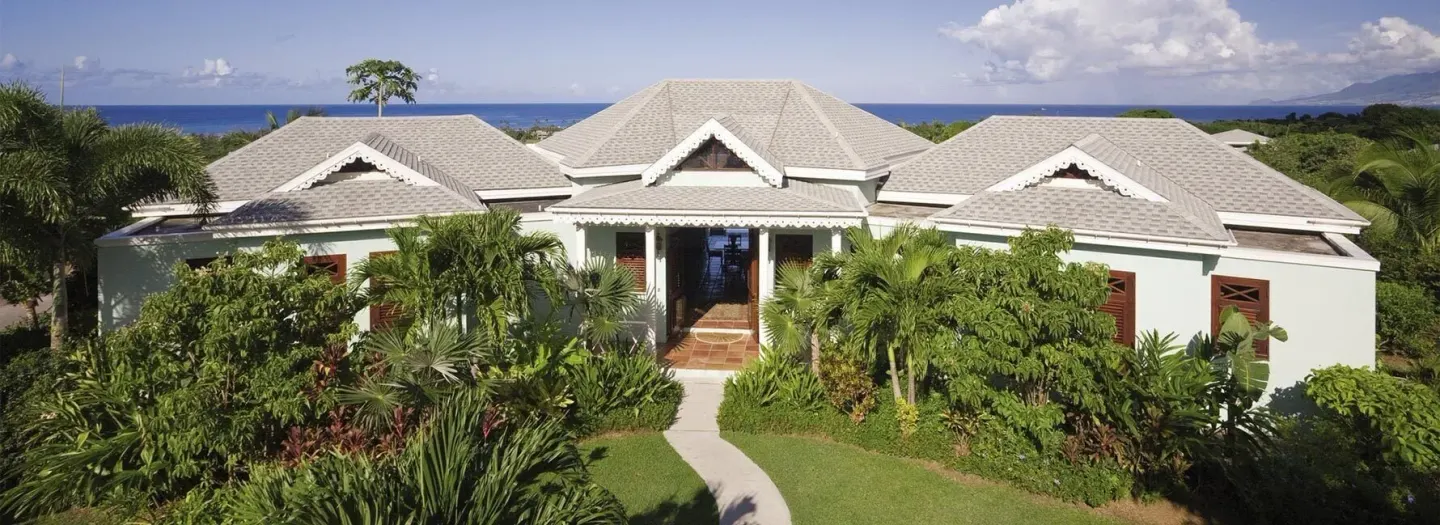 Resort villa exterior with tropical gardens and ocean beyond at Four Seasons Resort Nevis.