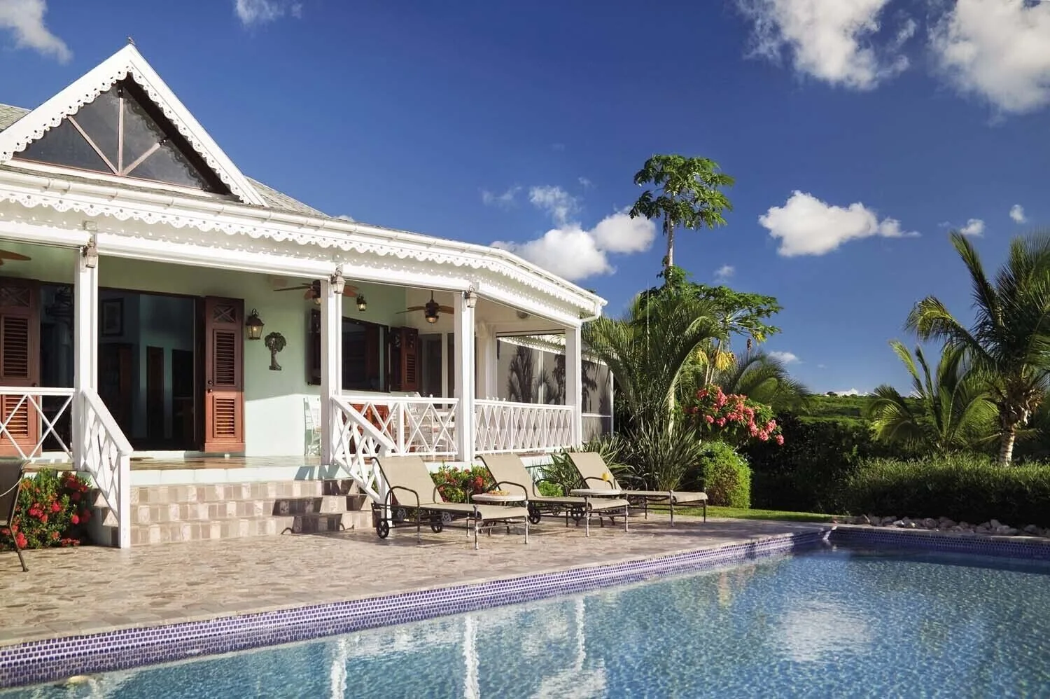 Villa pool beside a veranda and tropical garden at Four Seasons Resort Nevis.