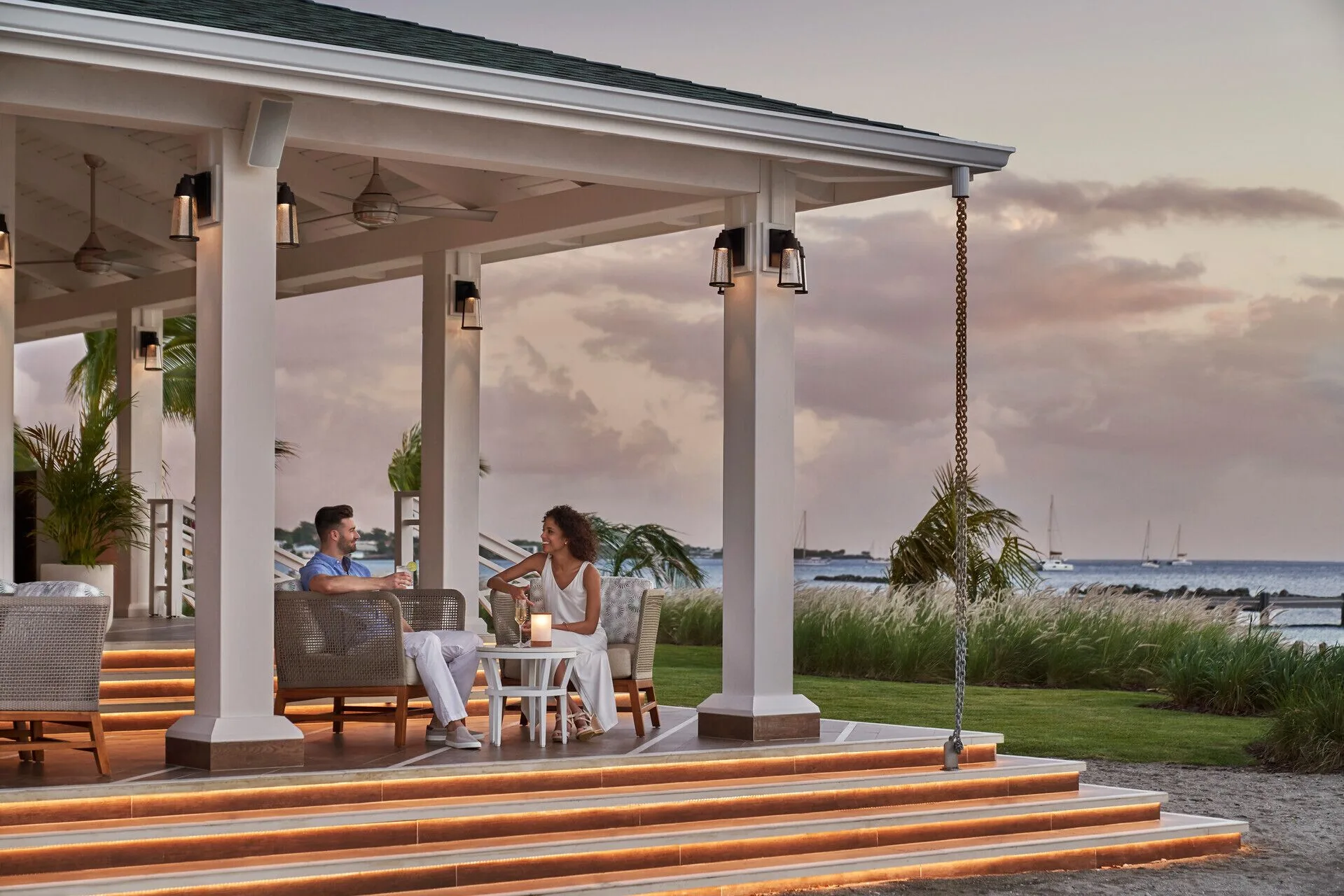 Couple seated on a covered oceanfront terrace at Four Seasons Resort Nevis.