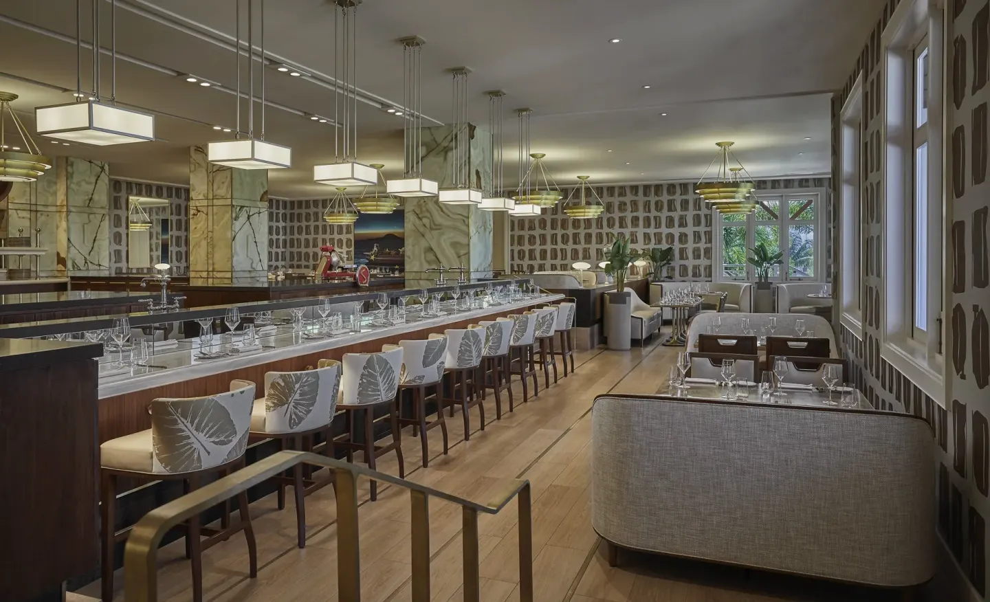 A restaurant bar and dining room set for service at Four Seasons Resort Nevis.