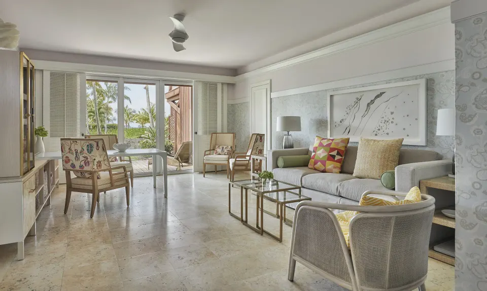 Kalinago Suite living room with sofa, chairs and terrace doors at Four Seasons Resort Nevis.
