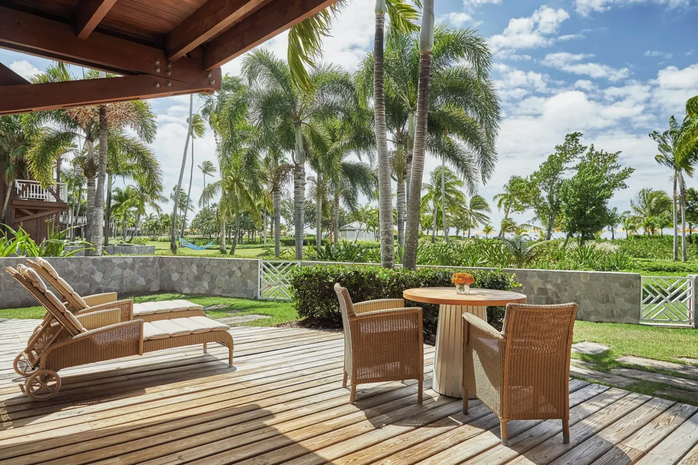 Kalinago Suite terrace with loungers, dining table and palm garden at Four Seasons Resort Nevis.