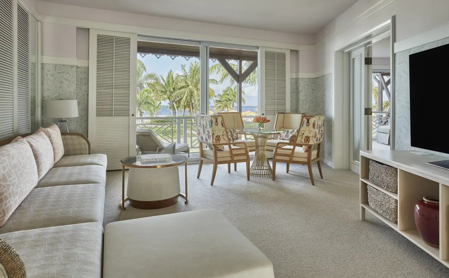 Poinciana Suite living area with balcony and palm views at Four Seasons Resort Nevis.