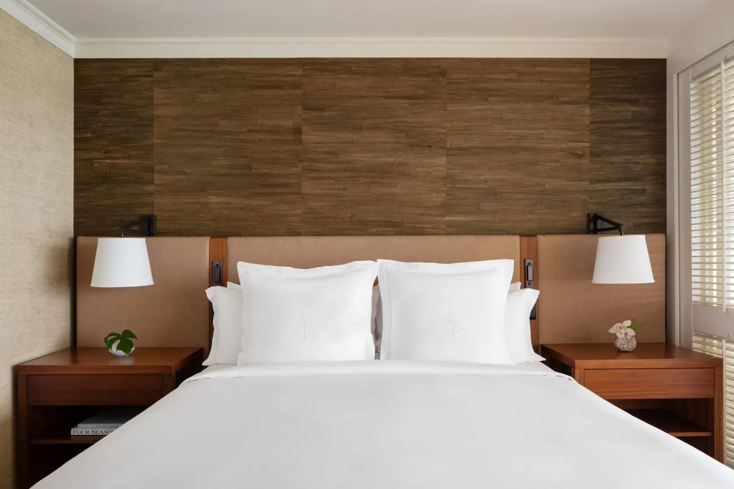 King bed with wood headboard wall at Four Seasons Resort Oahu at Ko Olina.