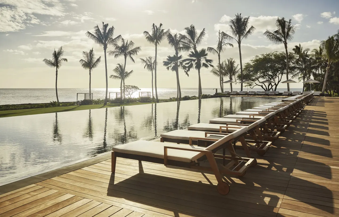 Infinity pool, loungers and palm trees at Four Seasons Resort Oahu at Ko Olina.