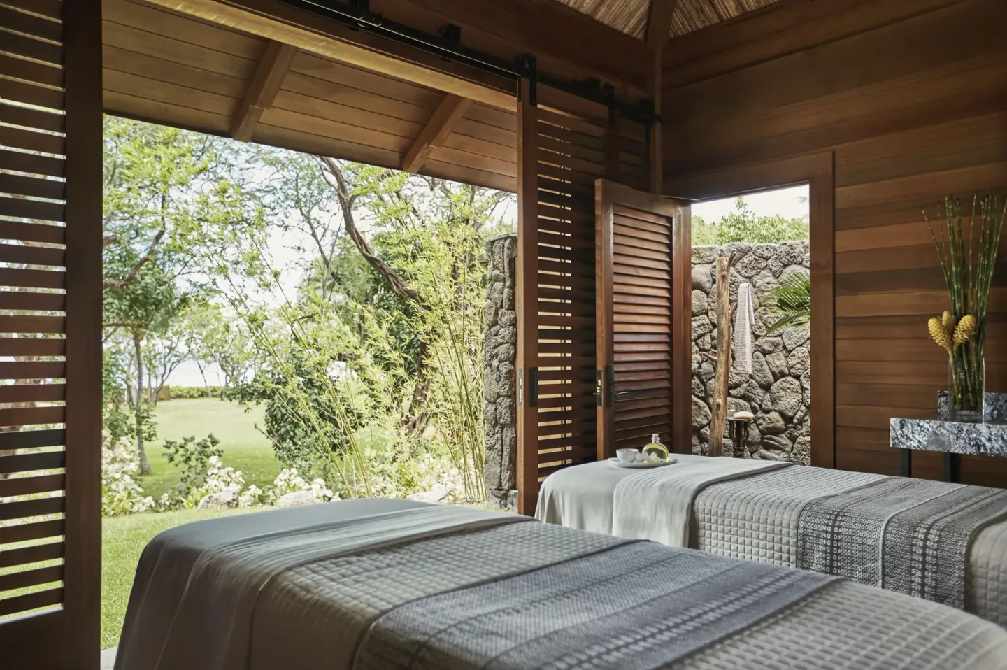 Open-air spa treatment room with two massage tables at Four Seasons Resort Oahu at Ko Olina.