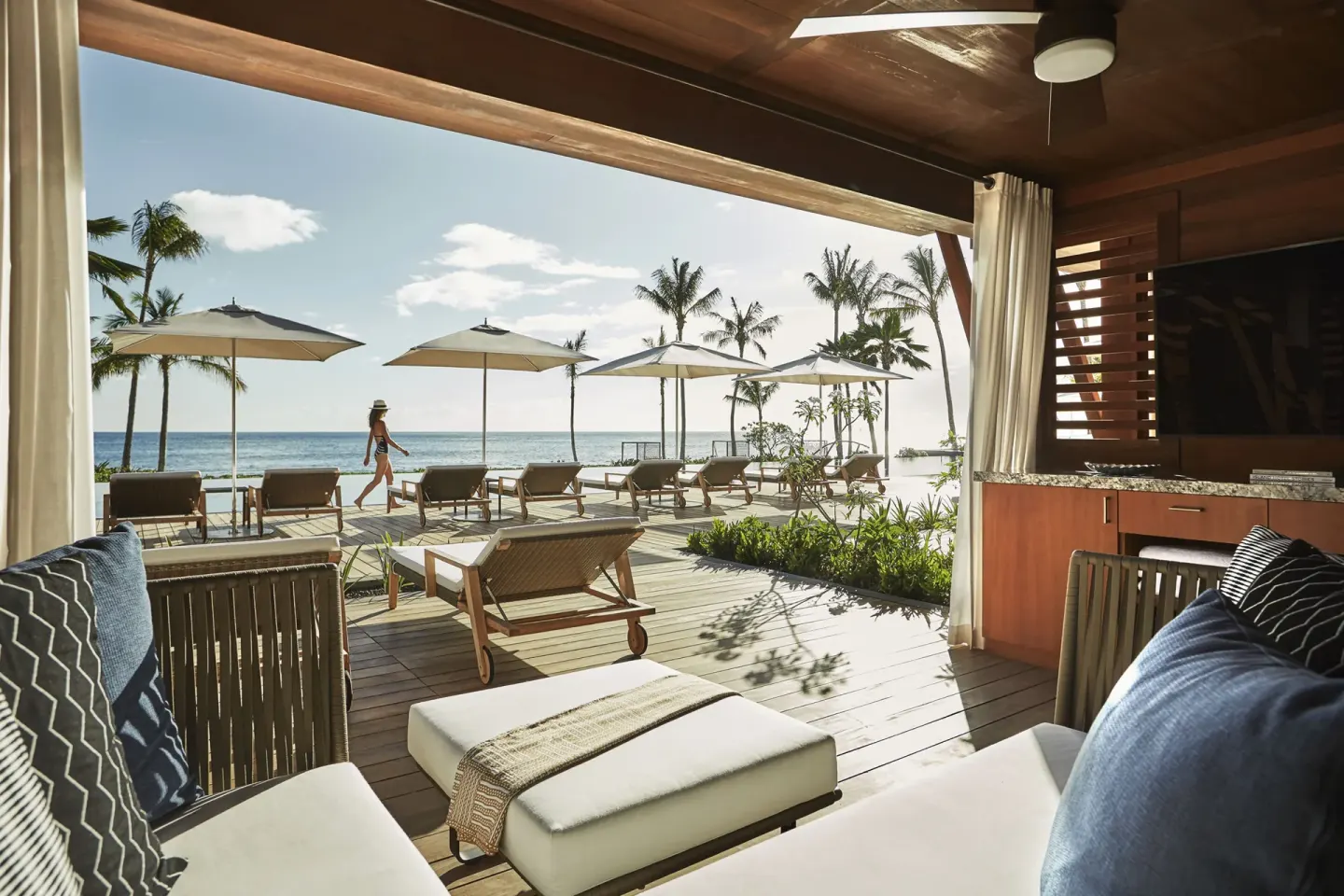 Shaded pool cabana overlooking loungers and ocean at Four Seasons Resort Oahu at Ko Olina.
